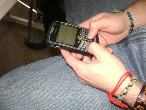 A student texts under the table with his Blackberry. Photo by Anna Swanson.