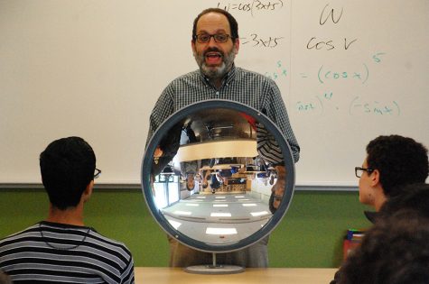 Physics teacher Michael Lerner demonstrates properties of light, holding a concave mirror up to his class and asking students, “what do you see?” Photo by Yuke Zheng