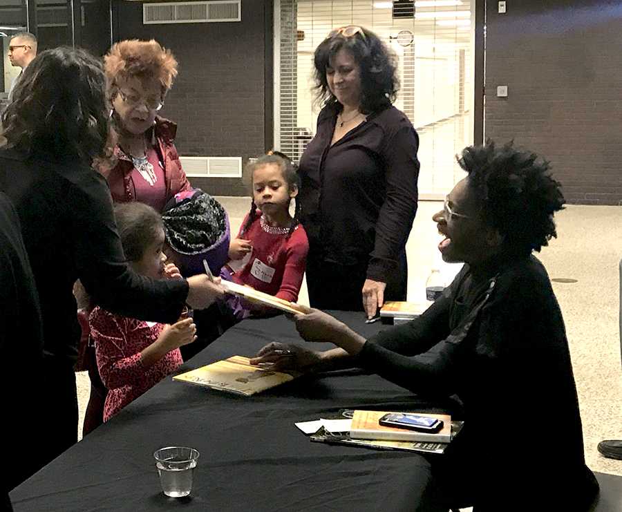 At the end of the evening, Jacqueline Woodson sat at her own table signing books while audience members enjoyed cookies and drinks that had been set up outside of the auditorium. Photo by Malinda Creel.