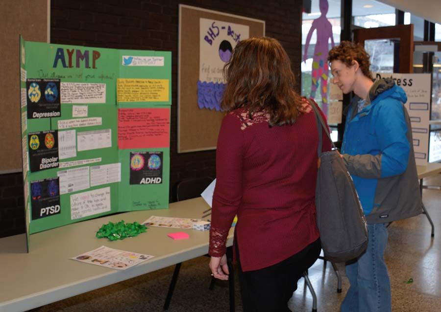 Students and staff learn about a project on mental health. Photo by Vivian Li.
