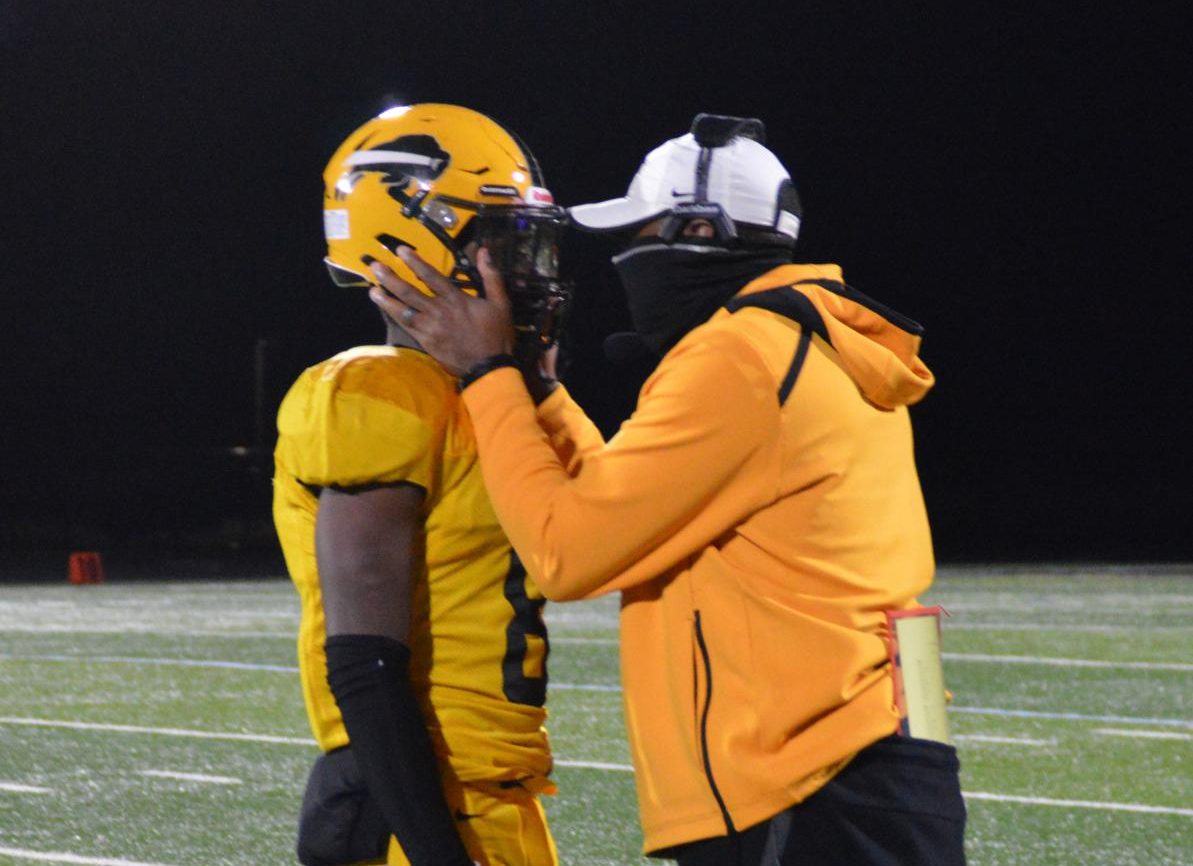 Creel speaks with quarterback Desmond Horne during the second-round playoff game on Oct. 16, 2020. The Bison defeated Warrensville 28-8.