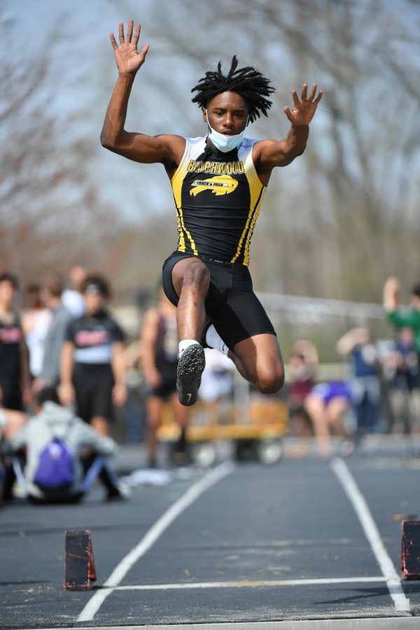 Senior+Jasir+Holmes+soars+in+the+long+jump.+He+will+be+advancing+to+regionals+in+the+4x100+and+4x200+relays.
