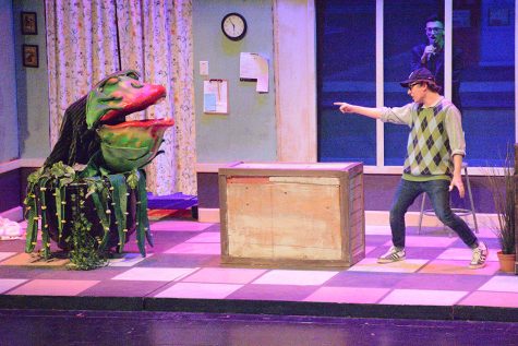 Seymour (Ian Ward) complains to Audrey II (Puppeteer Austyn Stout, Voice by Jonah Kaminsky) about her voracious appetite.  