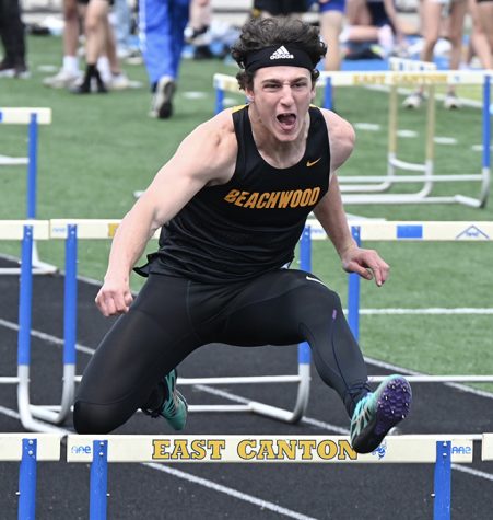 Senior Michael Keselman leaps a hurdle at the East Canton Invitational on April 8.