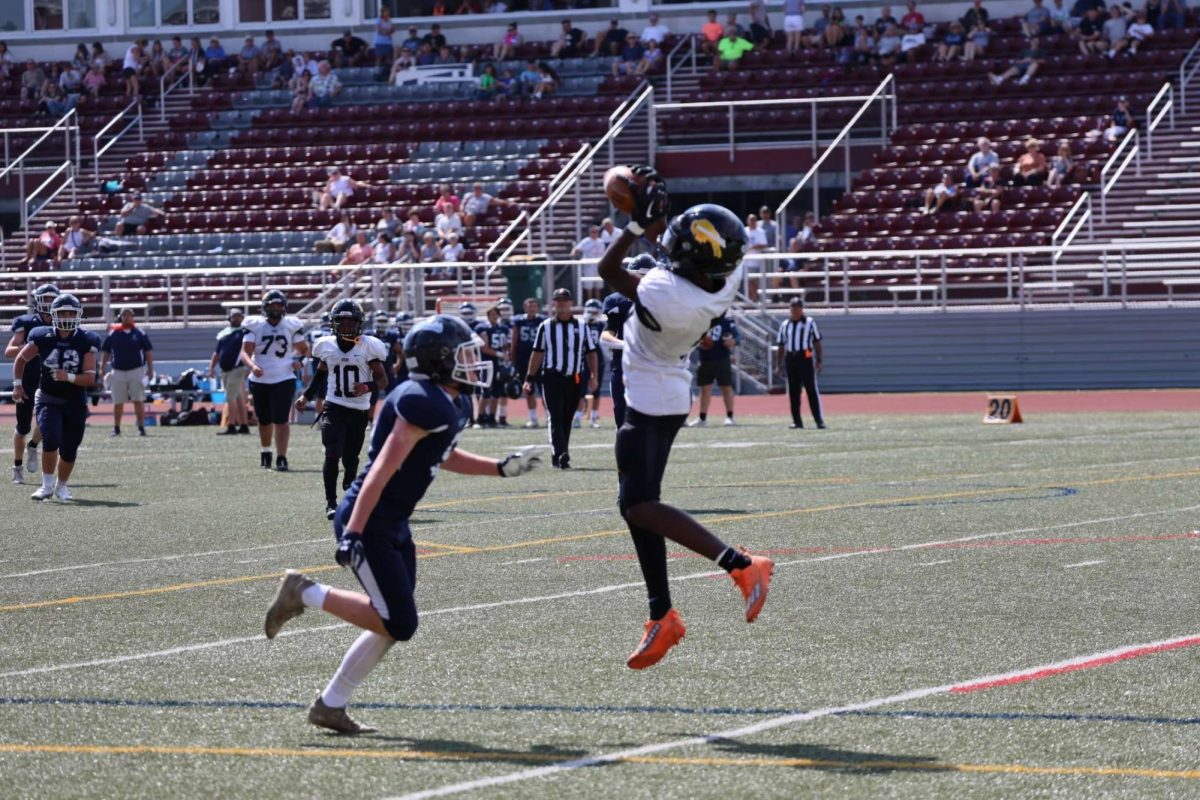 Freshman Eriq Walker leaps to catch a pass from Thomas, scoring a touchdown.