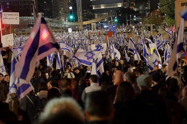 Israelis have been protesting since January against the coalition governments judicial reforms. Photo of Tel Aviv protest from Feb. 2023 by Lizzie Shaanan via Wikimedia Commons.