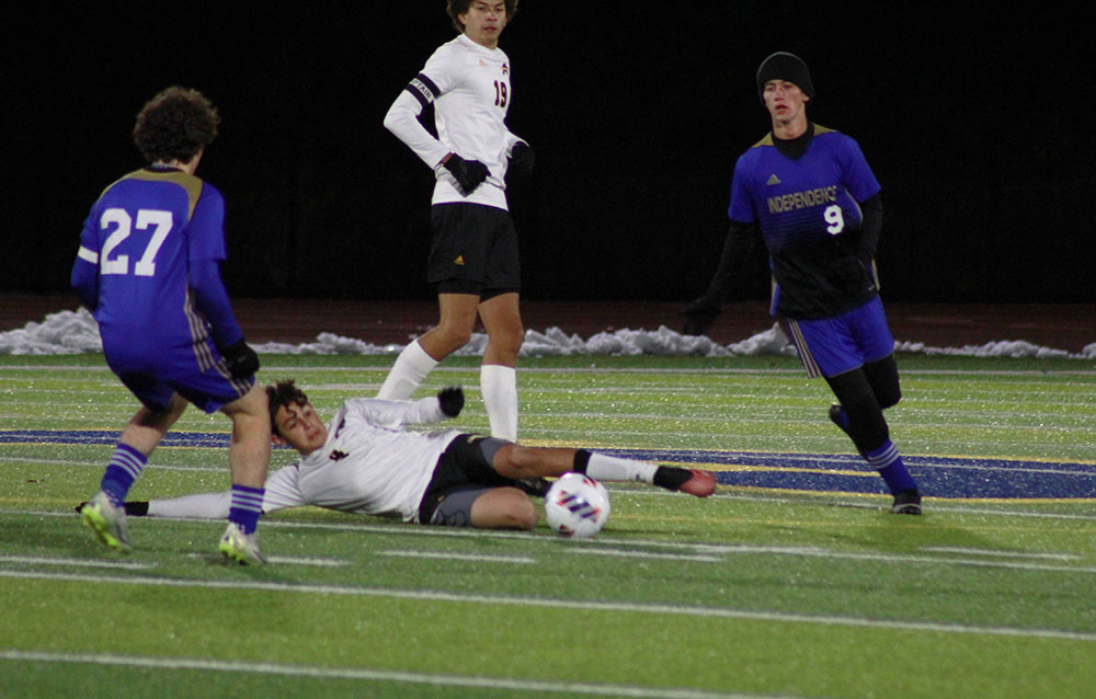 Senior center midfielder Leo Blond slides for a tackle to gain the ball. 