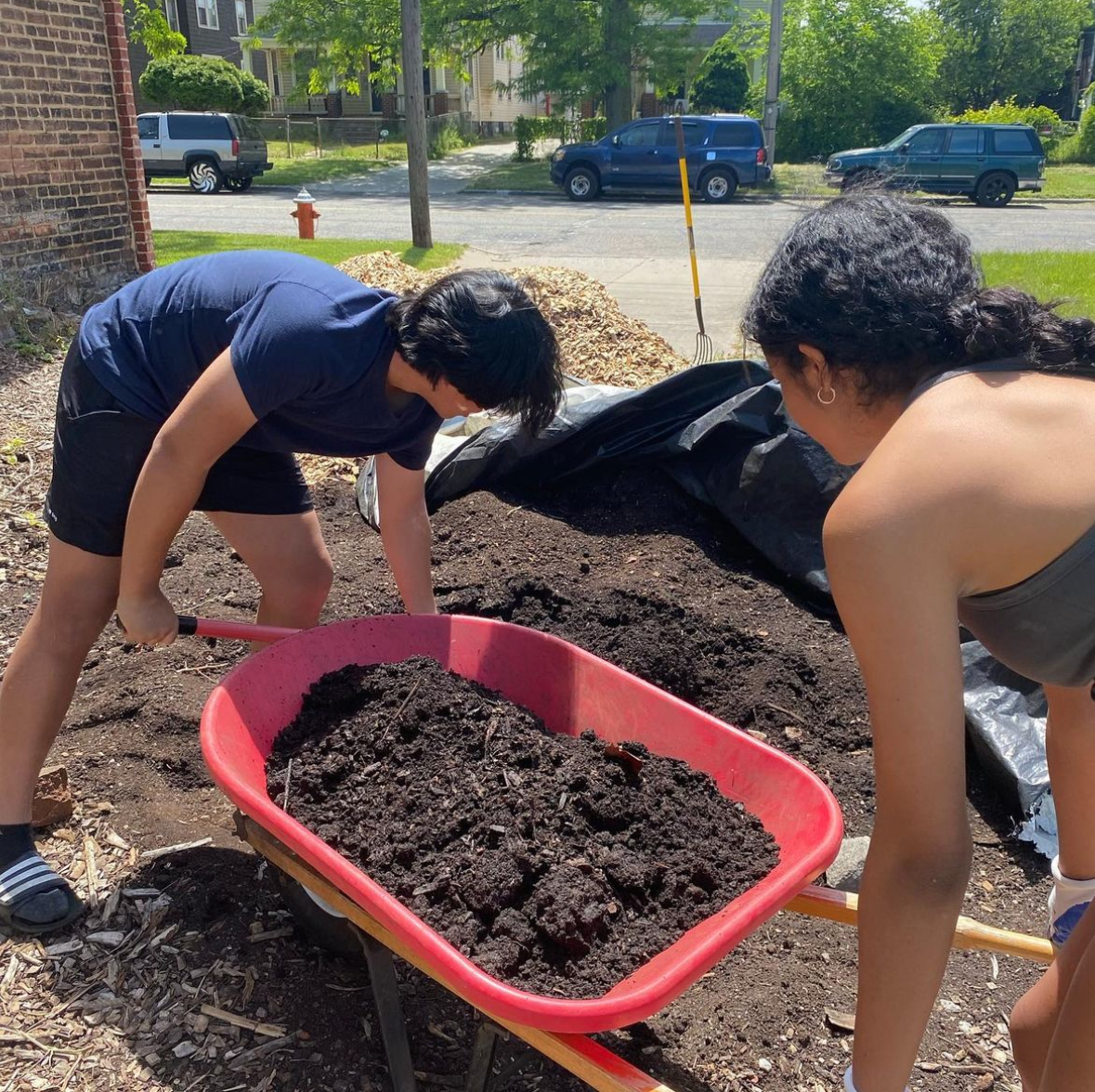 Seniors Arianna Preston and David You load mulch during the Hands on Helping event at Rust Belt Garden in Cleveland. 