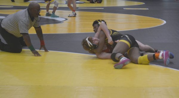 Junior Caleb Greenwood tries to pin his opponent at the Ron Madow Invitational on Dec. 8.