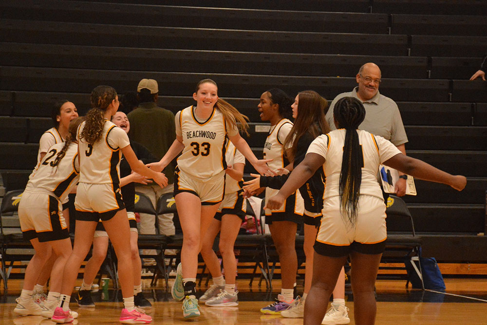 Goldi Aschkenasy walking onto the court with cheerful support from her teammates on senior night