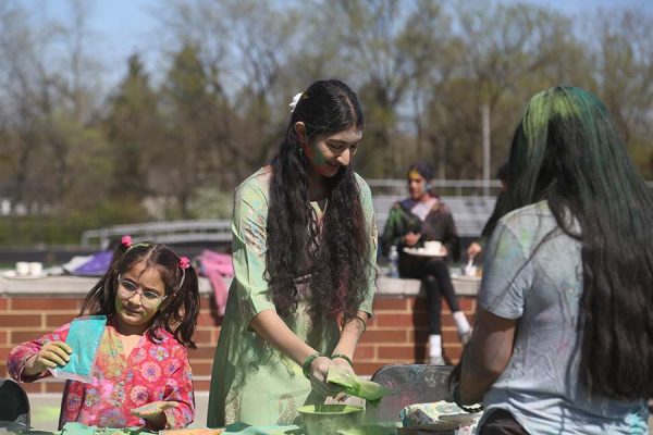 Junior Srishti Ithychanda pours colors for participants to toss.