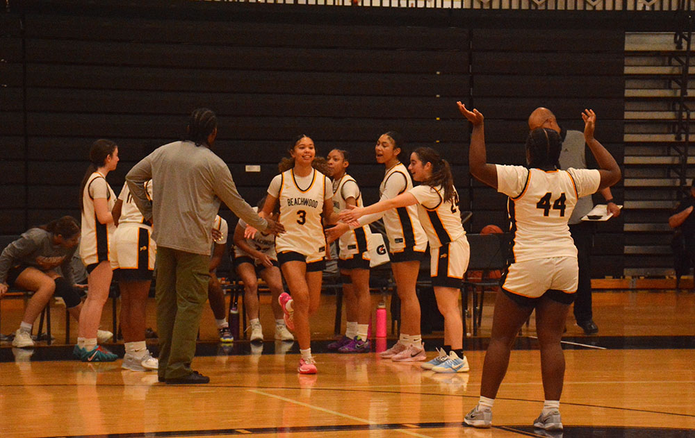 The team cheering on Marley Readance as she is announced onto the court.