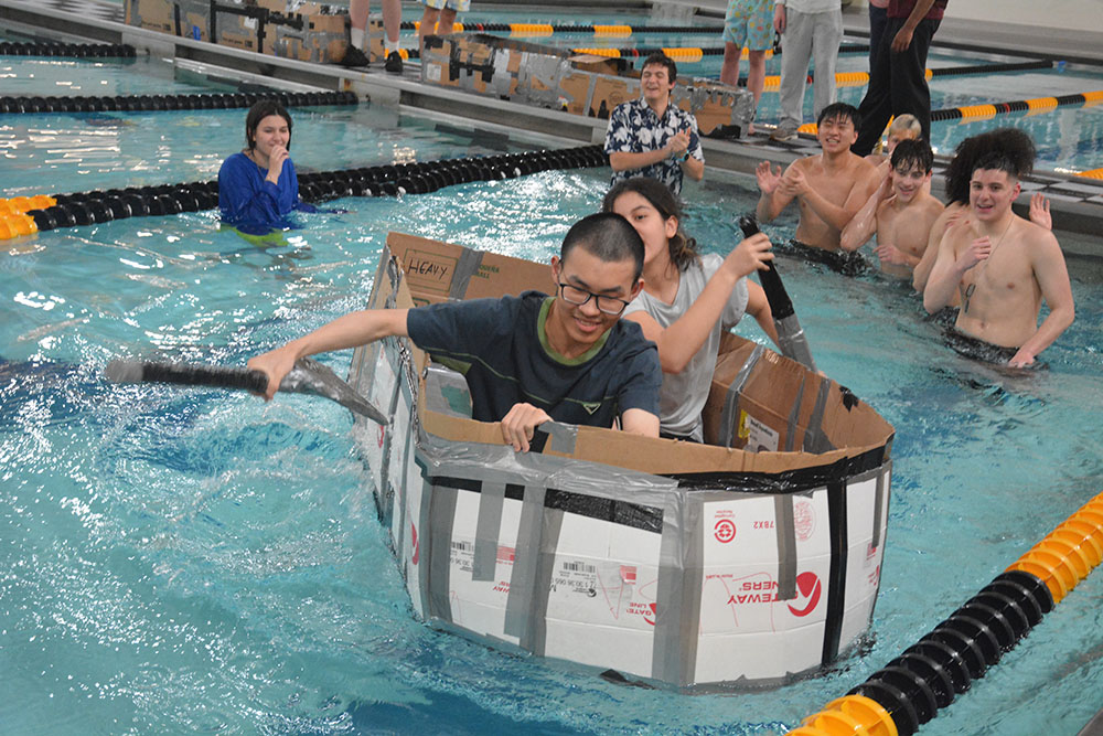 Student teams were tasked with designing and building boats made of only cardboard and tape that could float and be raced down and back in the pool.