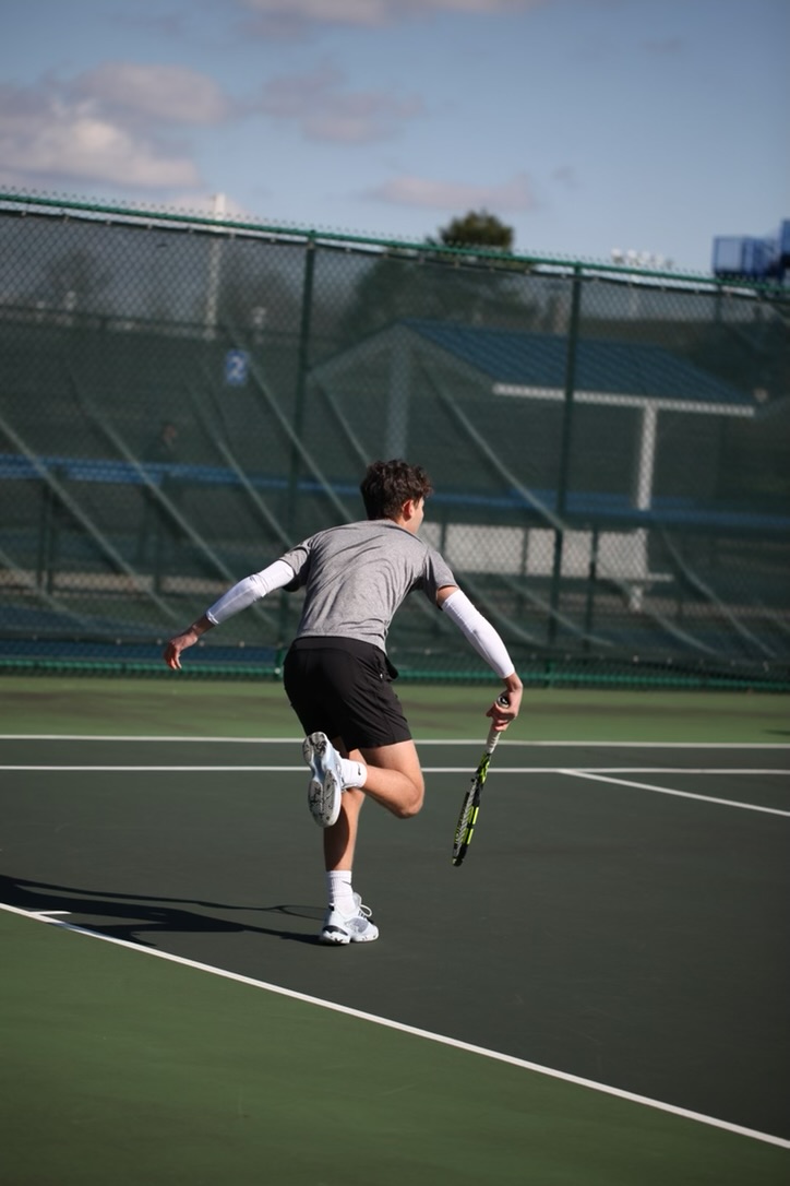Ari Synenberg makes a serve on the Beachwood courts during a tennis match last season. 