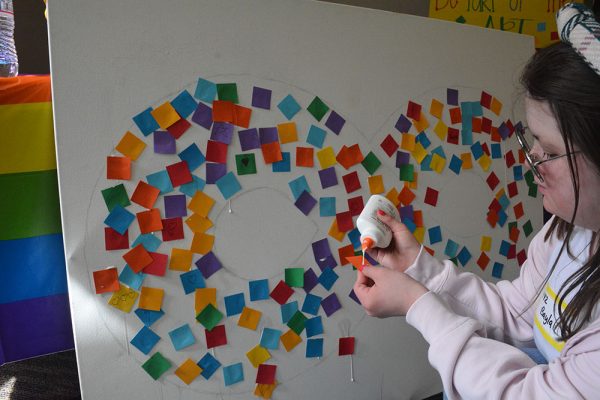 BHS student Bayla Socher contributes to the neurodiversity infinity symbol art piece. 